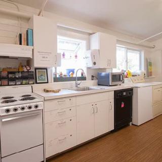A modern kitchen with white cabinets and appliances.