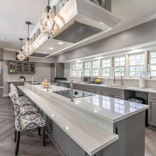 A modern kitchen with a large island and stylish pendant lighting.