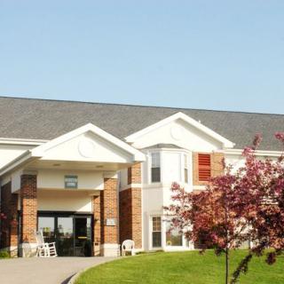 A suburban building with a main entrance and surrounding greenery.