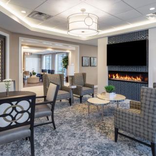 A modern lounge area featuring a cozy seating arrangement and a stylish fireplace.