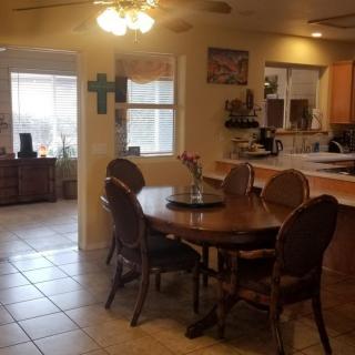 A cozy dining area with a wooden table and chairs, adjacent to a kitchen.