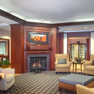 A cozy hotel lobby with a fireplace and comfortable seating area.