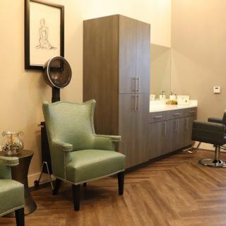 A modern salon interior with stylish furniture and a hair styling area.