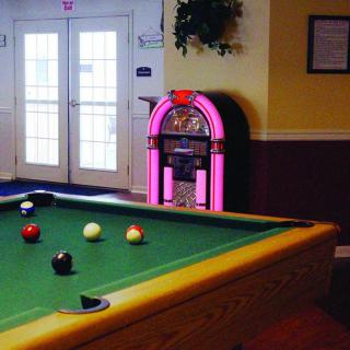 A cozy game room featuring a pool table and a classic jukebox.