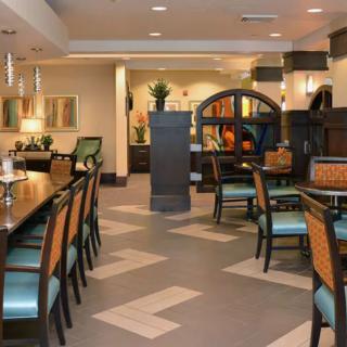 A well-lit and elegantly furnished restaurant dining area featuring tables and chairs.