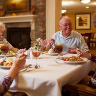 A group of elderly people enjoying a meal together at a restaurant.