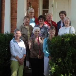 A group of women posing together outside a building.