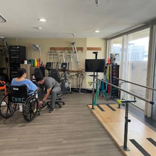 A rehabilitation center showcasing patients receiving therapy with healthcare professionals in a well-equipped environment.