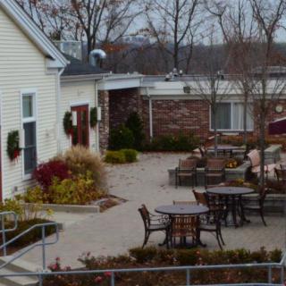 An outdoor patio area with tables and chairs surrounded by buildings in a winter setting.