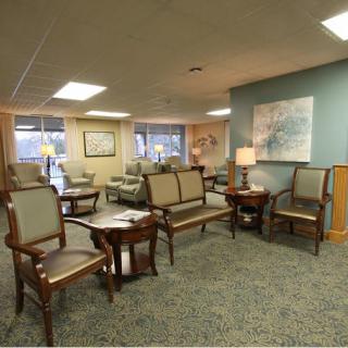 A spacious waiting room with arranged seating and warm lighting.
