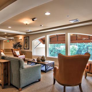 A cozy lounge area featuring comfortable seating and large windows that let in natural light.