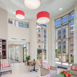 A modern lobby area with large windows, stylish furniture, and bright lighting.