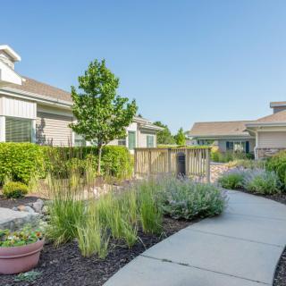 A tranquil residential neighborhood with well-maintained gardens and a winding walkway.