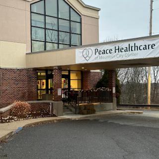 Entrance of Peace Healthcare facility with a prominent exterior sign.