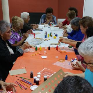 A group of seniors engaging in a painting and crafts session together.
