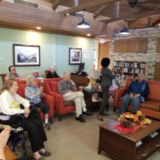 A group of elderly people gathered in a cozy living room for a social event.