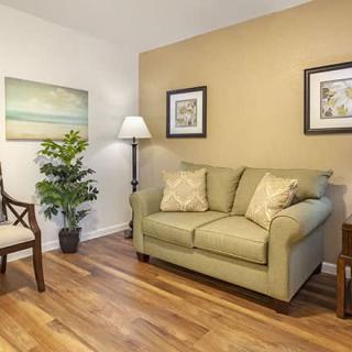 A cozy living room with a sofa, armchair, and decorative elements.