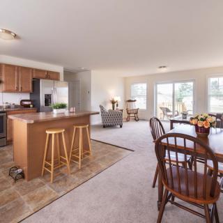 Spacious open floor plan featuring a kitchen with an island, dining area, and living room with abundant natural light.
