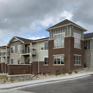 A modern residential building with a brick exterior under a cloudy sky.
