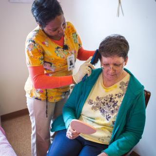 A healthcare professional performs a hearing test on a patient in a clinic setting.