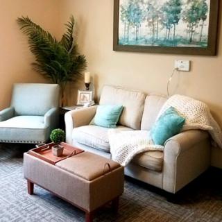 A cozy living room with a sofa, an armchair, and decorative elements.