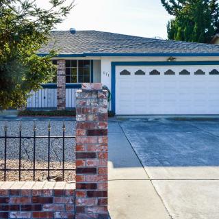 A suburban house with a two-car garage and brick fencing.