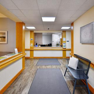 A reception area with a front desk and a waiting bench.
