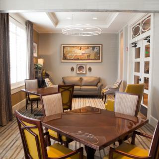 A cozy living room with a sofa, chairs, and a table, featuring warm colors and elegant decor.