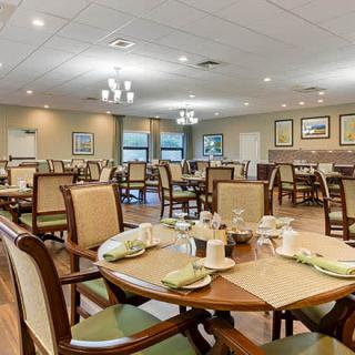 A spacious dining area with neatly arranged tables and chairs, set for service.
