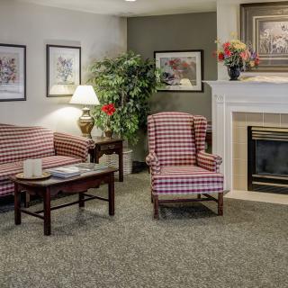 A cozy living room with plaid furniture and a fireplace.