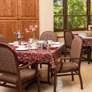 A cozy dining room table set for a meal, featuring elegant dishware and a floral centerpiece.