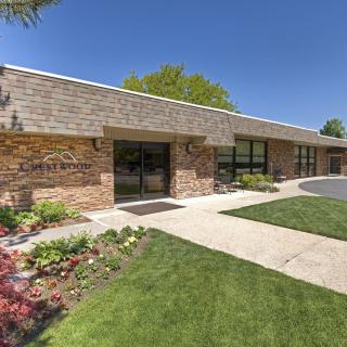 A commercial office building with a well-maintained landscape on a sunny day.