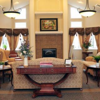An elegantly designed living room featuring a central fireplace, ornate decor, and comfortable seating.
