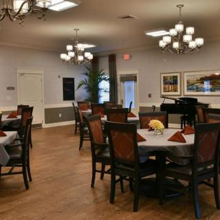 Elegant dining area with neatly arranged tables and chandeliers.