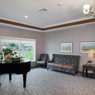 A cozy living room with a piano and comfortable seating.
