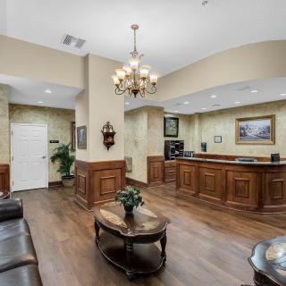 A stylish lobby featuring a reception desk, chandelier, and comfortable seating.