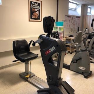 A well-equipped gym area featuring specialized exercise equipment for rehabilitation and fitness training.