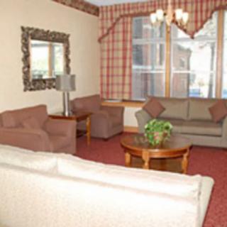 A cozy living room with sofas, a coffee table, and a decorative mirror.