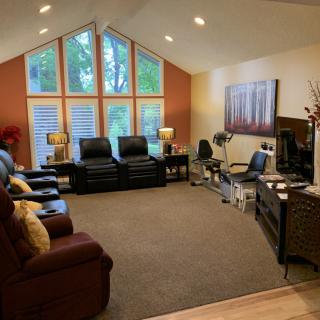 A modern living room featuring recliners and large windows.