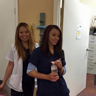 Two healthcare professionals standing in a clinic environment.