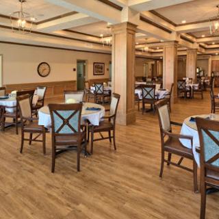 A spacious and elegantly designed dining area with wooden furniture and a warm ambiance.