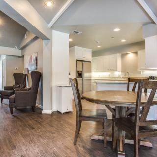 An open-concept space featuring a modern dining area leading into a sleek kitchen.
