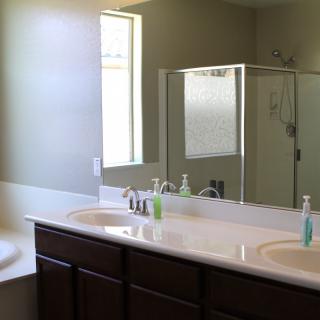 A modern bathroom with a double sink, bathtub, and shower.