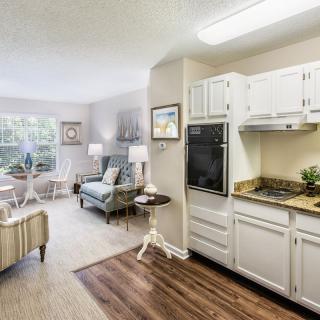 A cozy open-concept apartment with a modern kitchen and a comfortable living room.