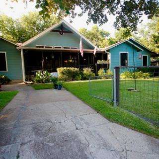 A charming exterior view of a green house with a well-maintained garden and inviting entrance.