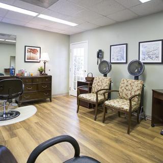 A cozy waiting room with chairs and office decor.