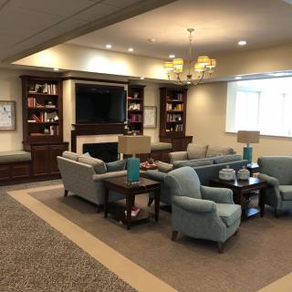 A cozy living room with a seating area, bookshelves, and a television.
