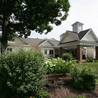 A well-maintained residential building with a lush garden and trees.