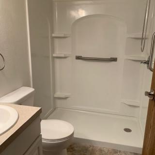 A clean bathroom with a shower, toilet, and sink.