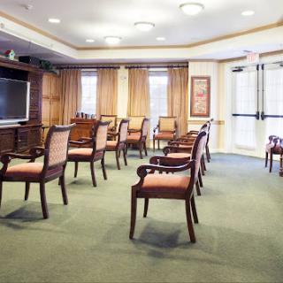 A well-lit meeting room with wooden chairs arranged around the space.